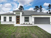 Charming single-story home featuring a two-car garage, modern design, and well-manicured lawn at 2209 Sw 178Th St, Ocala, FL 34473