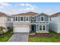 Charming two-story home boasts a beautiful stone facade, manicured lawn and covered entryway at 4149 Lana Ave, Davenport, FL 33897