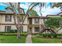 Inviting townhome featuring charming exterior details, lush landscaping, and stairway to the second floor at 600 Northern Way # 404, Winter Springs, FL 32708