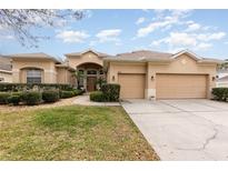 Charming home featuring a well-manicured lawn, lush landscaping, and a three-car garage at 6942 Remington View Ct, Orlando, FL 32829