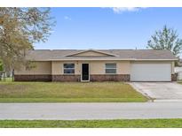 Charming single-story home with a well-manicured lawn and two-car garage at 741 Maderia Ct, Kissimmee, FL 34758