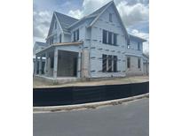 Two-story home exterior under construction with covered patio, with visible framing and siding at 166 Hammock Preserve Loop, Winter Garden, FL 34787