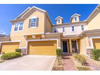 Charming townhome featuring a two-car garage and well-maintained landscaping at 17437 Promenade Dr, Clermont, FL 34711