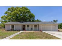 Charming single-story home features a well-maintained lawn, tasteful landscaping, and an attached two car garage at 2402 Greenwood St, Deltona, FL 32738