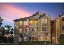 Multi-story condo building with dual balconies and lush landscaping, set against a colorful sunset sky at 3406 Soho St # 201, Orlando, FL 32835