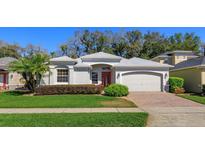 Charming single-story home with a well-manicured lawn, brick driveway, and attractive landscaping at 4963 Rock Rose Loop, Sanford, FL 32771