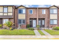 Charming brick townhome featuring a well-manicured lawn and inviting entrance at 5042 Downing St # 5, Orlando, FL 32839