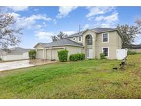 Two-story home featuring an attached three-car garage and manicured landscaping at 9532 Water Fern Cir, Clermont, FL 34711