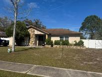 Charming single-story home with stone accents and manicured front yard landscaping at 12927 Montana Woods Ln, Orlando, FL 32824