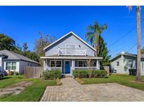 Charming two-story home featuring a welcoming front porch and blue door at 1518 Fabian Ave, Orlando, FL 32807