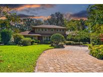 Charming two-story home featuring a brick driveway and lush landscaping at 1606 The Oaks Dr, Maitland, FL 32751