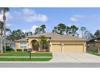 Charming single-story home with a three-car garage, well-manicured lawn, and beautiful landscaping at 2582 Greenwillow Dr, Orlando, FL 32825