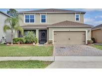 Charming two-story home featuring a manicured lawn, a two-car garage, and beautiful landscaping at 411 Lazio Cir, Debary, FL 32713