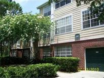 Charming exterior of a multi-story home with a brick base and mature landscaping at 13013 Mulberry Park Dr # 222, Orlando, FL 32821