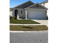 Charming single-story home with a two-car garage and well-maintained front lawn at 1548 Planters Point Rd, Kissimmee, FL 34744