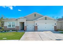 Charming single-Gathering home featuring a well-manicured lawn, two-car garage, and beautiful stone accents at 1636 Barberry Dr, Kissimmee, FL 34744