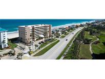 Stunning aerial view of a beachfront condo building, highlighting its proximity to the ocean, golf course, and surrounding homes at 4651 S Atlantic Ave # 2030, Ponce Inlet, FL 32127