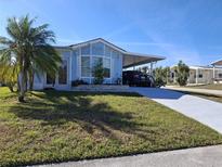 Charming home with a carport and well-maintained lawn and a palm tree in a desirable neighborhood at 50989 Highway 27 # 130, Davenport, FL 33897