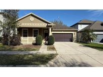 Charming home features a manicured lawn, a two-car garage, and a welcoming front porch at 7525 Colbury Ave, Windermere, FL 34786
