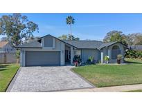 Charming home with a well-manicured lawn and paver driveway, showcasing curb appeal at 825 Rosemere Cir, Orlando, FL 32835