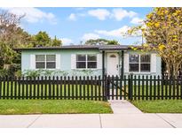 Charming single-story home features a black picket fence, lush green lawn, and inviting front porch at 864 Naples Dr, Orlando, FL 32804