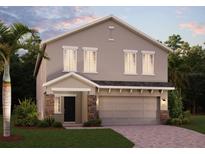 Two-story home showing the front door, two-car garage, a paved driveway, and a palm tree in the front yard at 872 Scrub Oak Hammock Rd, Davenport, FL 33837