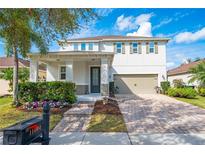 Charming two-story home with a well-manicured lawn, beautiful landscaping, and a brick-paved driveway at 11604 Acosta Ave, Orlando, FL 32836