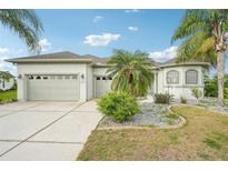 Charming single-story home featuring lush landscaping, a three-car garage, and a well-manicured lawn at 12018 Se 175Th Loop, Summerfield, FL 34491