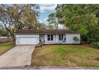 Charming single-story home with a well-manicured lawn and attached garage with a concrete driveway at 142 Habersham Dr, Longwood, FL 32779