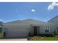 Charming single-story home with stone accents, a well-manicured lawn, and a two-car garage at 14709 Erice Ave, Clermont, FL 34714