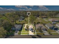 This aerial view showcases the property's layout, mature trees, and a well-maintained lawn at 1716 Terry Ne Cir, Winter Haven, FL 33881