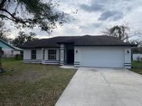 Charming single-story home with a two-car garage and well-maintained lawn at 1721 Sandalwood Sw Cir, Winter Haven, FL 33880