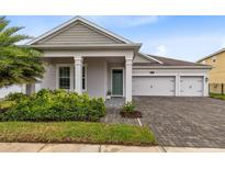 Charming single-story home with a manicured front yard and a three-car garage at 2930 Wordsmith Rd, Kissimmee, FL 34746