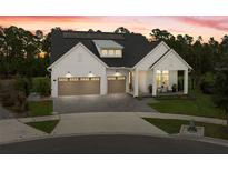 Beautiful modern farmhouse with a three-car garage and covered porch on a landscaped lawn at 3135 Vanguard Ct, St Cloud, FL 34771