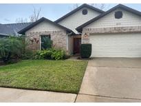 Charming single-story home with well-manicured lawn and an attached two-car garage at 3210 Little Oak Way, Orlando, FL 32812