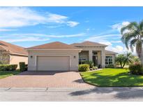 Charming single-story home with a well-manicured lawn, brick driveway, and attached two-car garage at 4068 Stone Creek Loop, Lake Wales, FL 33859