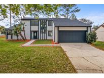 Charming two-story home features a well-manicured lawn, inviting entryway, and attached two-car garage at 4940 Spring Run Ave, Orlando, FL 32819