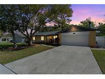 Charming single-story home with stone accents, a well-manicured lawn, and an attached two-car garage at 1514 Meadowlark St, Longwood, FL 32750