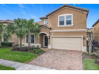 Charming two-story home featuring a brick driveway, attached two car garage and tropical landscaping at 1602 Lima Ave, Kissimmee, FL 34747
