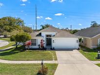 Charming single Gathering home featuring a manicured lawn, fresh white paint, and an attached two car garage at 239 Bronze Leaf Ct, Apopka, FL 32703