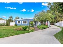 Charming blue single story home with a well-manicured lawn and a brick-paved walkway to the front door at 2413 Weber St, Orlando, FL 32803