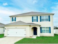 Charming two-story home featuring a well-manicured lawn and inviting front entrance at 2837 Palatino Lane, Tavares, FL 32778