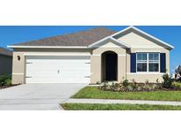 Charming one-story home featuring a two-car garage, blue shutters, and fresh landscaping at 2908 Moulin Rd, Davenport, FL 33837