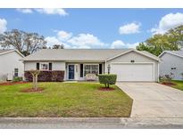 Charming single-story home with a well-manicured lawn, tidy landscaping, and attached two car garage at 5349 Tangelo St, Leesburg, FL 34748