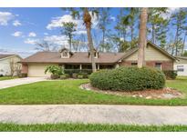 Charming single-story home featuring a well-manicured front yard, mature trees, and an attached two-car garage at 743 Riverbend Blvd, Longwood, FL 32779