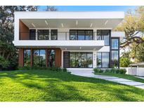 Modern two-story home with clean lines, a balcony, and well-manicured front lawn at 806 Edgewater Dr, Orlando, FL 32804