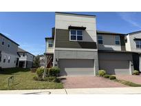 Modern two-story townhome featuring a two-car garage and a well-maintained front yard with green landscaping at 1522 Bantam Way, Winter Park, FL 32792