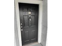 A black front door provides secure entry with key lockbox and visible unit number at 204 E South St # 5058, Orlando, FL 32801