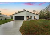 Charming single-story home featuring a dark garage door and modern architectural details at 2246 Sw 167Th Pl, Ocala, FL 34475