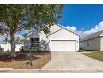 Charming single-story home features a well-manicured lawn, a two-car garage, and a classic, inviting facade at 547 Madina Cir, Davenport, FL 33837